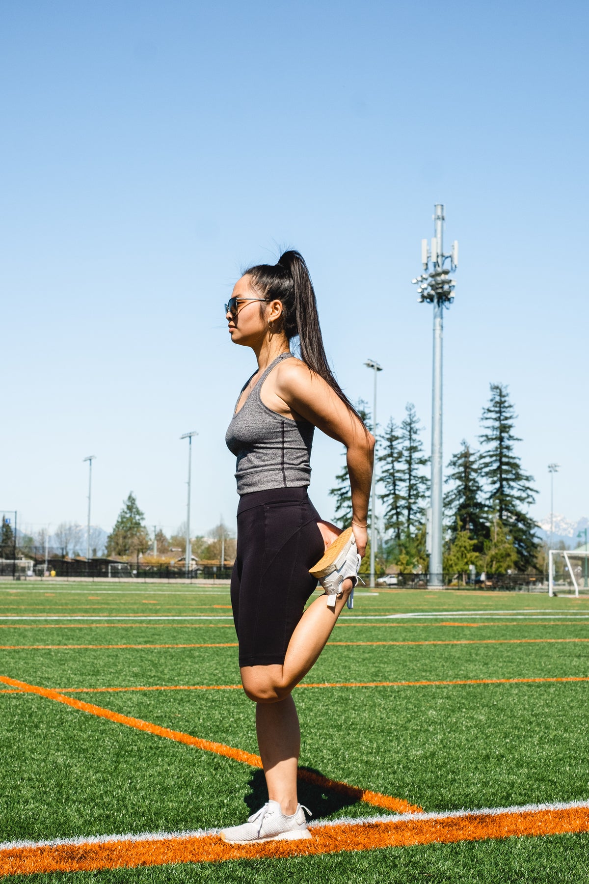 woman-stretches-her-leg-while-standing-on-a-sport-field